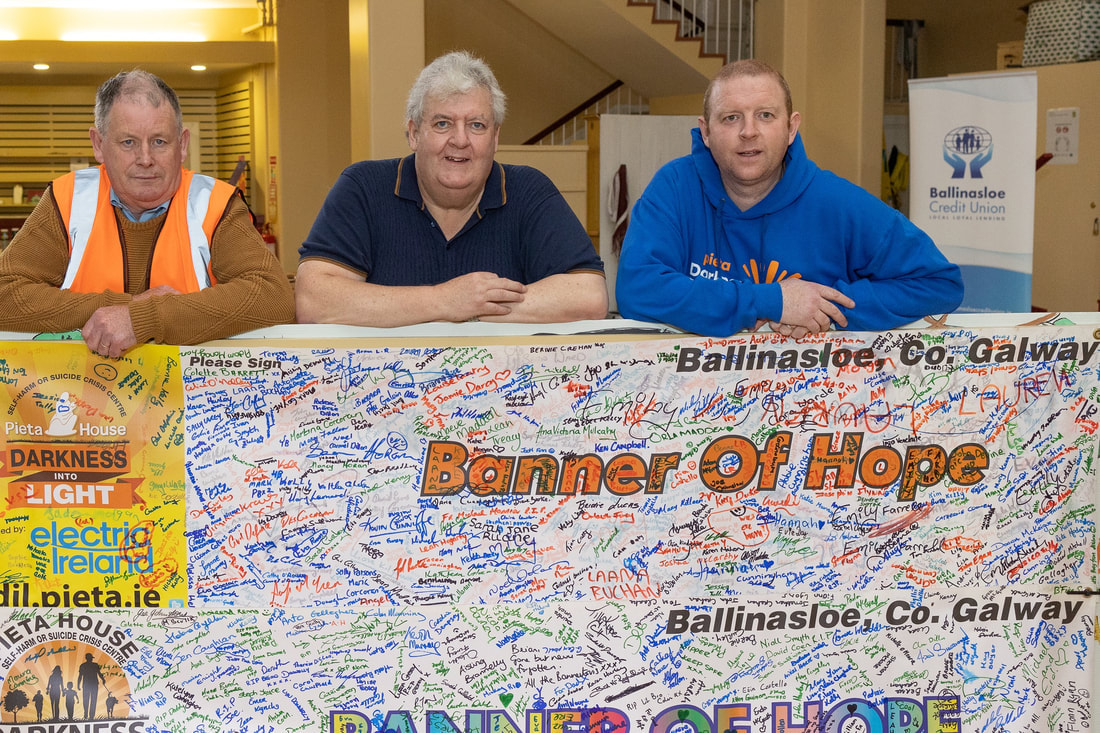Kerrill Burke, Brian Derrane and Aidan Lonergan along with the Banner of Hope signed by the participants for the 2022 Darkness into Light fundraiser.